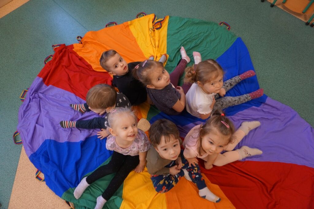 Dzieci siedzą na  środku chusty