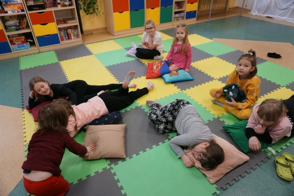 Dzieci relaksują się leżąc na poduszkach
