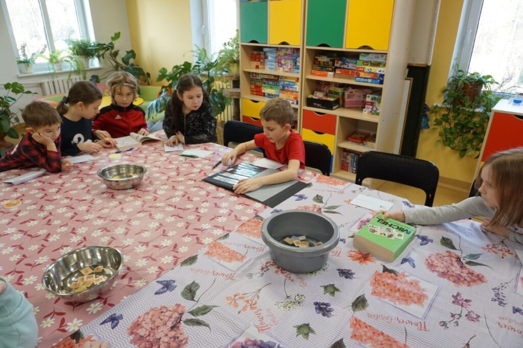 Dzieci oglądają klasery ze znaczkami