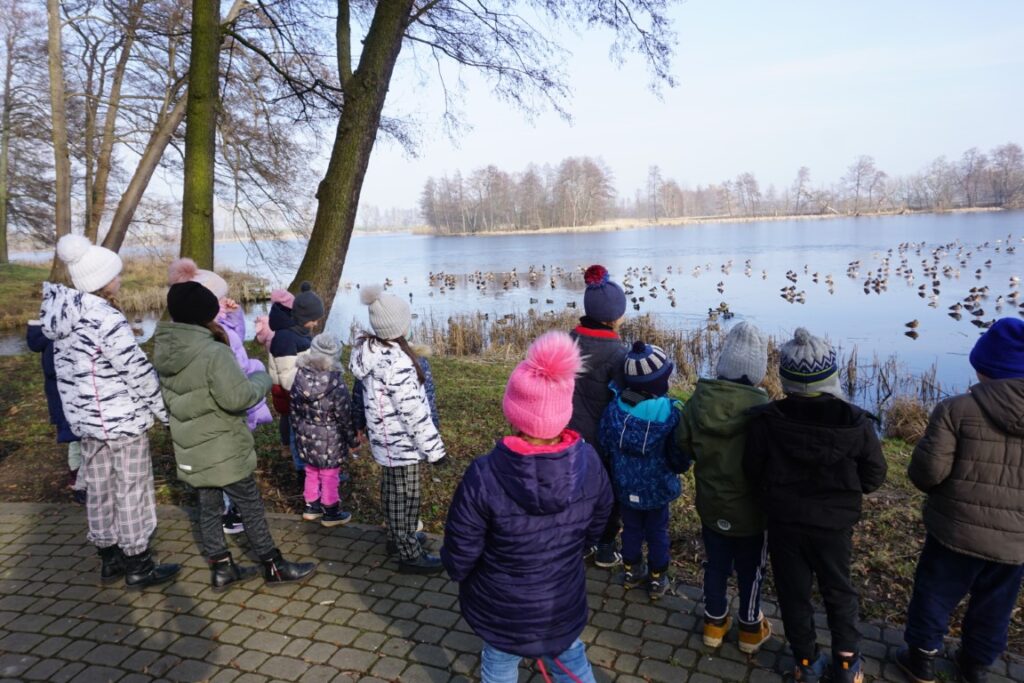 Dzieci obserwują znaczki na jeziorze