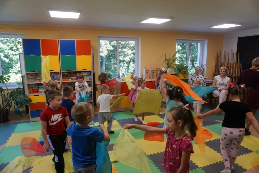 Dzieci wymachują kolorowymi chustkami