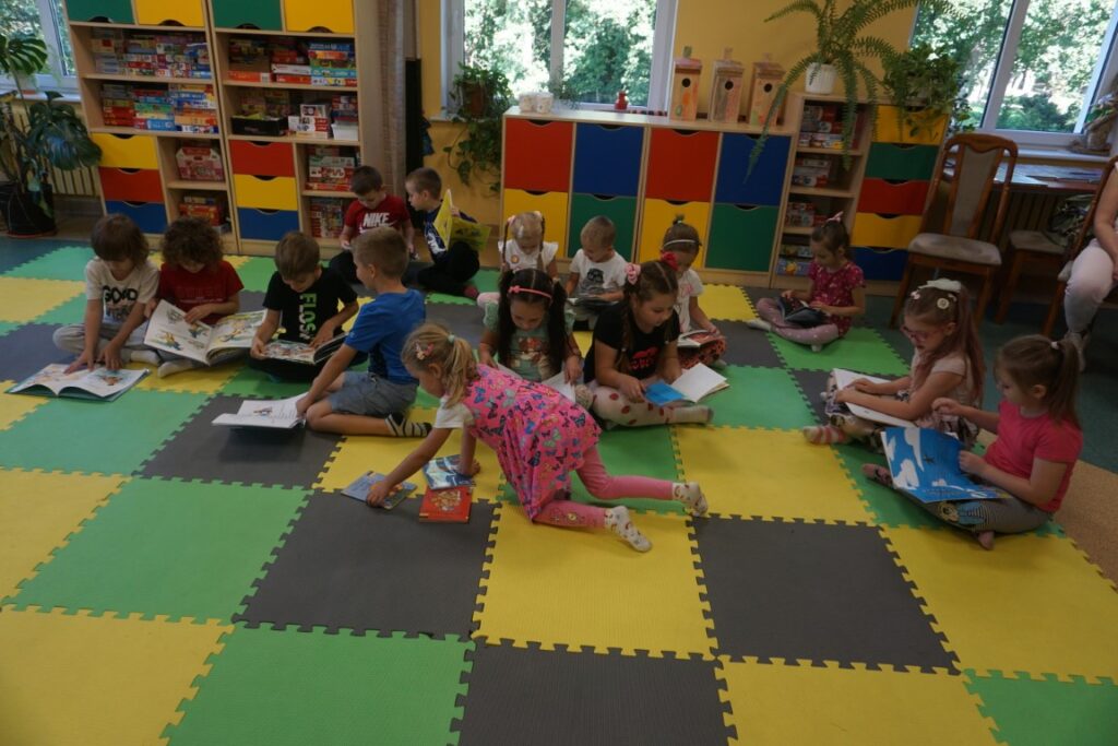 Dziewczynki przyczepiają kartę na ścianie