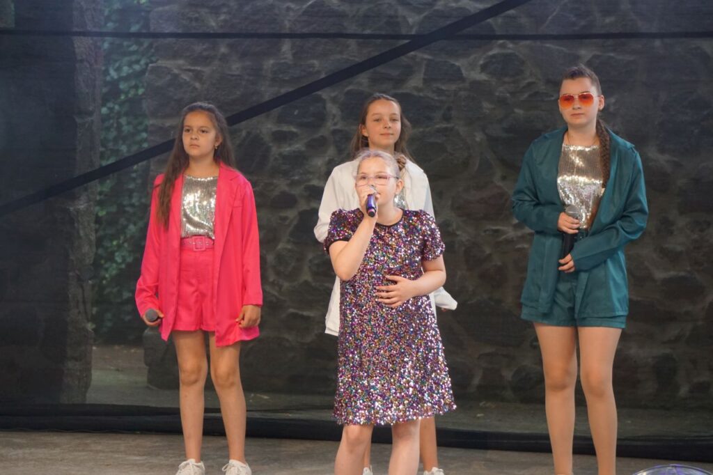 scena, soliści, śpiew, mury w tle, dzieci
