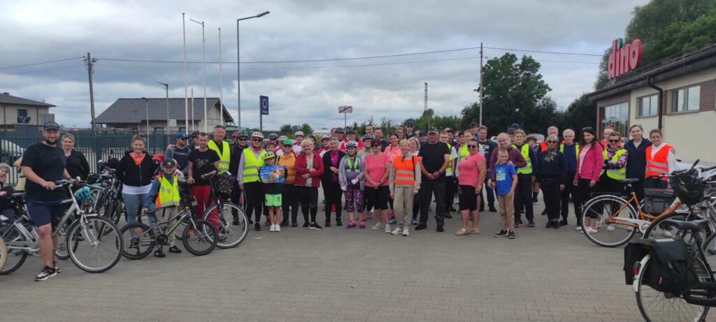Zdjęcie grupowe rowerzystów, sklep Dino. parking przed sklepem z kostki, rowery