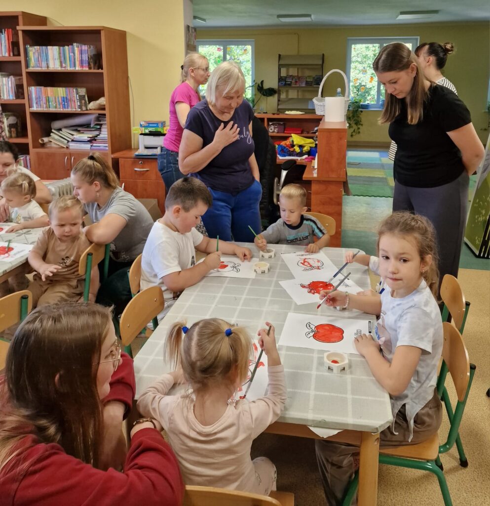 Akademia Malucha, dzieci malujące farbkami owoce pod opieka swoich opiekunów