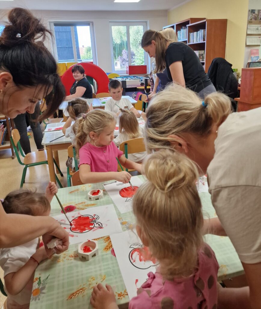 Akademia Malucha, dzieci malujące farbkami owoce pod opieka swoich opiekunów