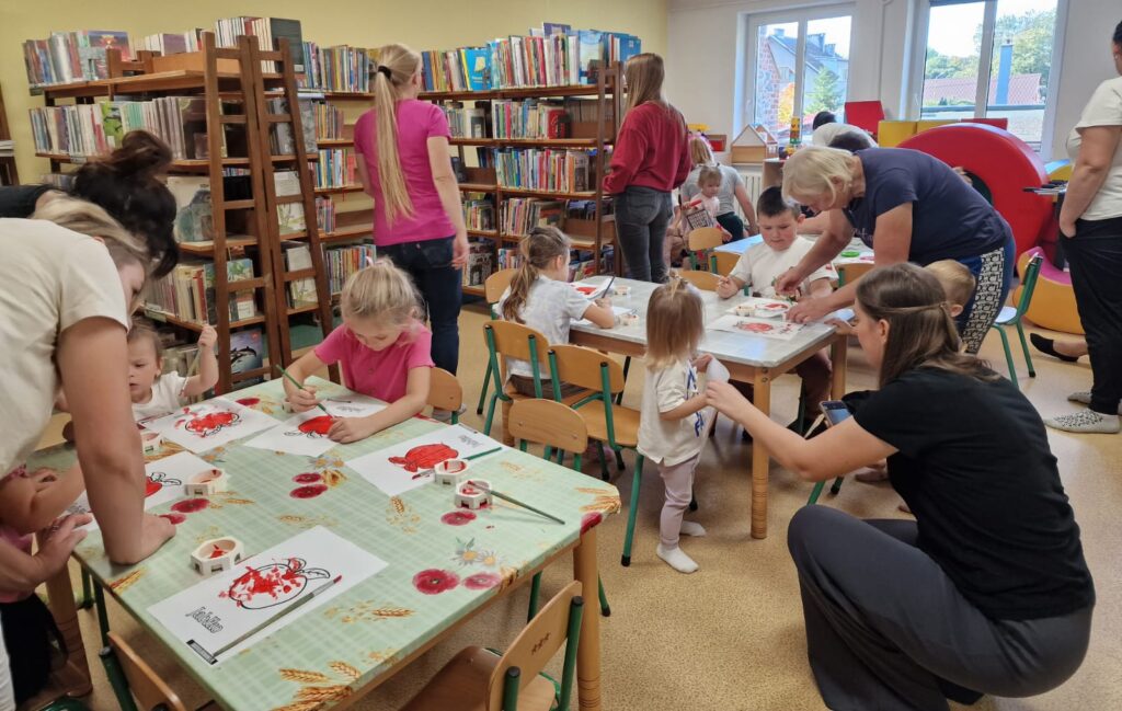Akademia Malucha, dzieci malujące farbkami owoce pod opieka swoich opiekunów