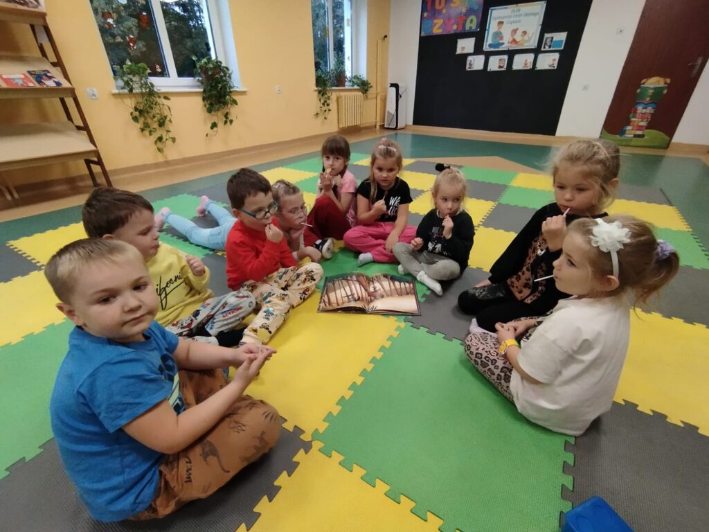 Dzieci, siedzą na macie, książeczka