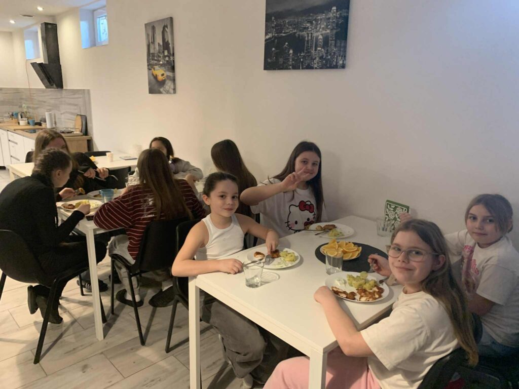 Dzieci jedzące śniadanie przy stołach