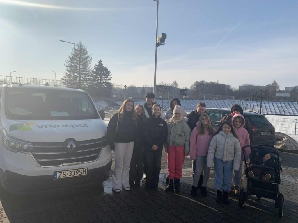 Dzieci - wokaliście w zimowej scenerii przed busem firmy Wreespol