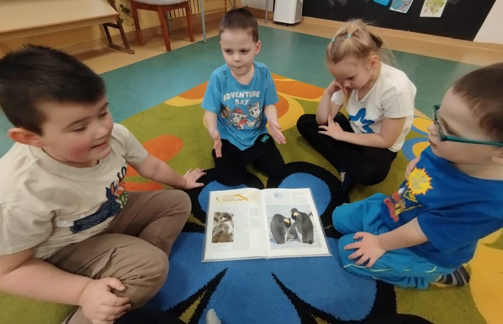 Dzieci z siedzące na dywanie z książeczką