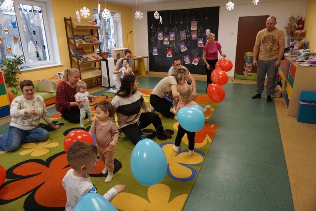 Dzieci z opiekunami bawiące się balonami