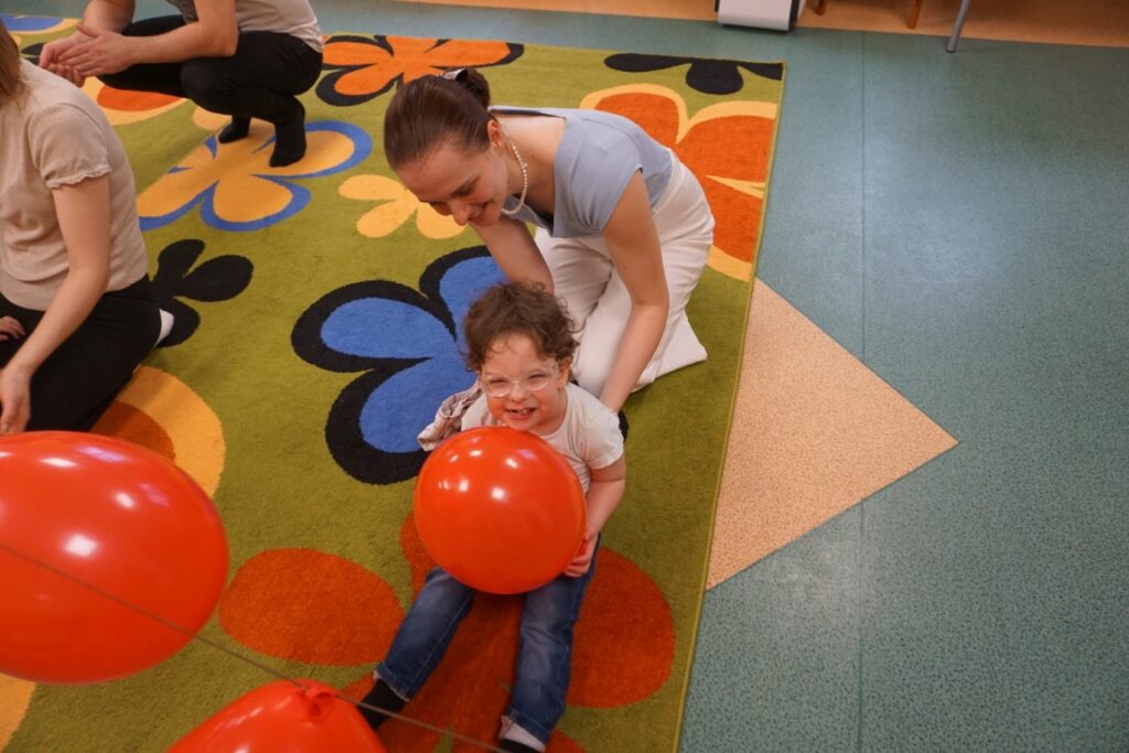 Dzieci z opiekunami bawiące się balonami