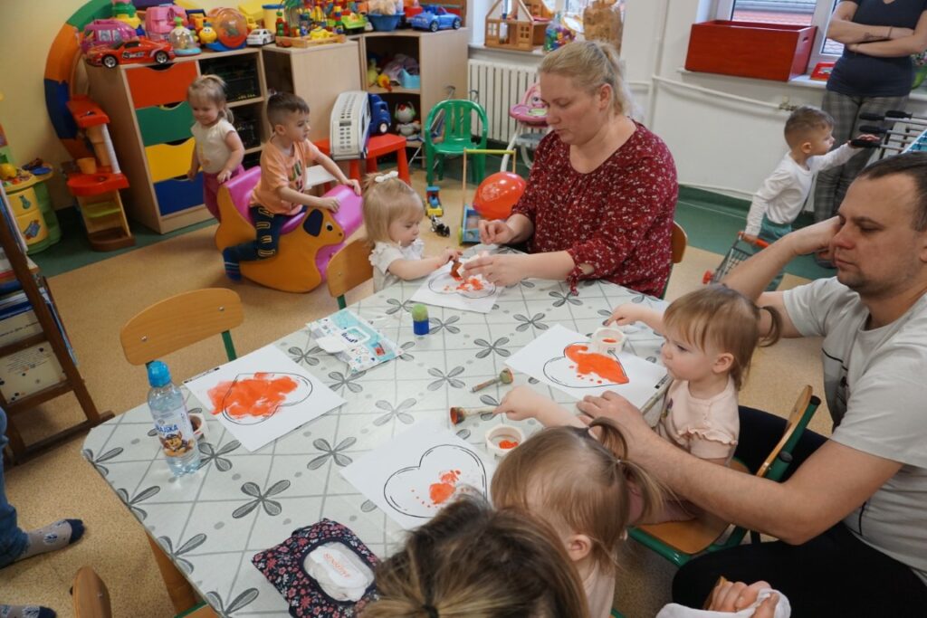 Dzieci przy stoliczkach malujące serca