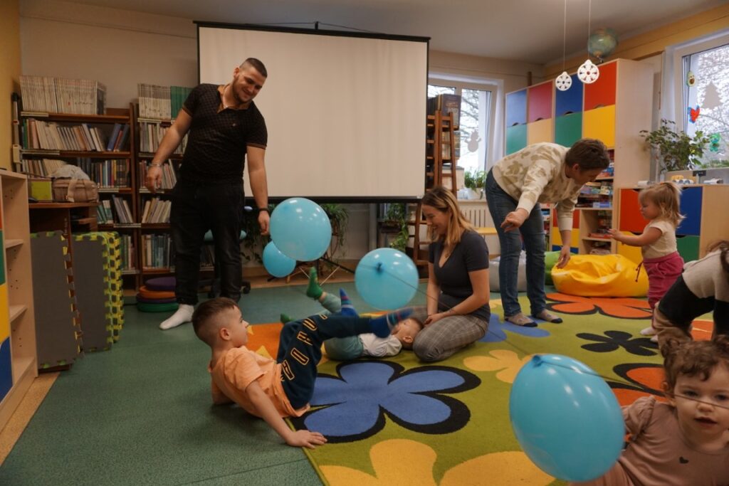 Dzieci z opiekunami bawiące się balonami