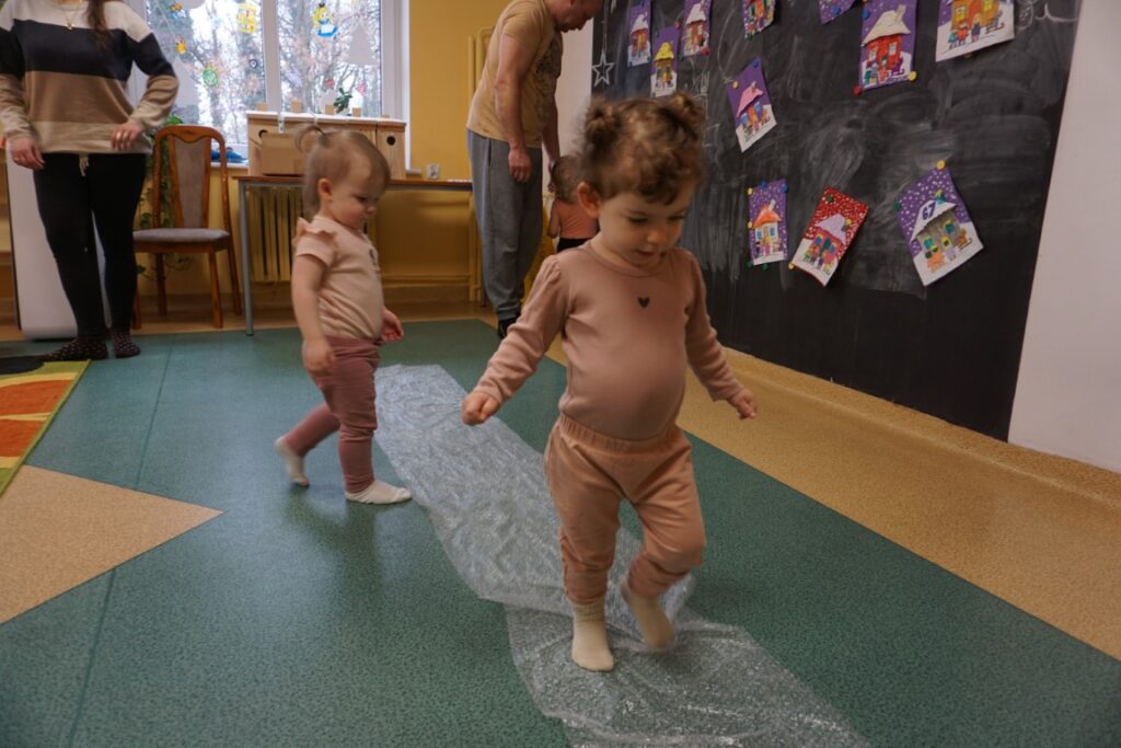 Dzieci chodzące boso po folii bąbelkowej