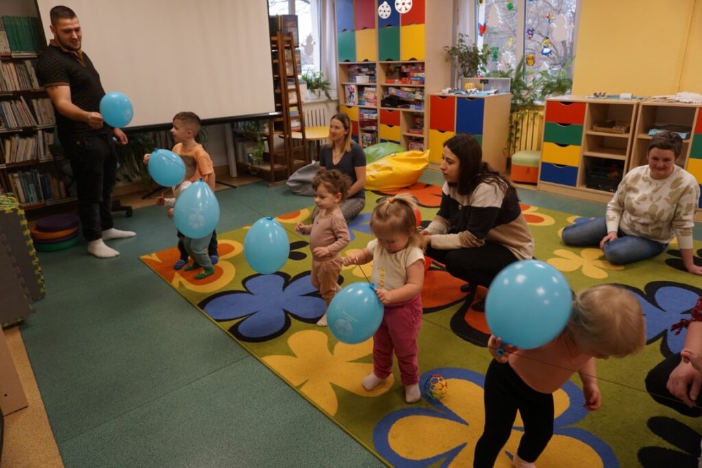 Dzieci z opiekunami bawiące się balonami