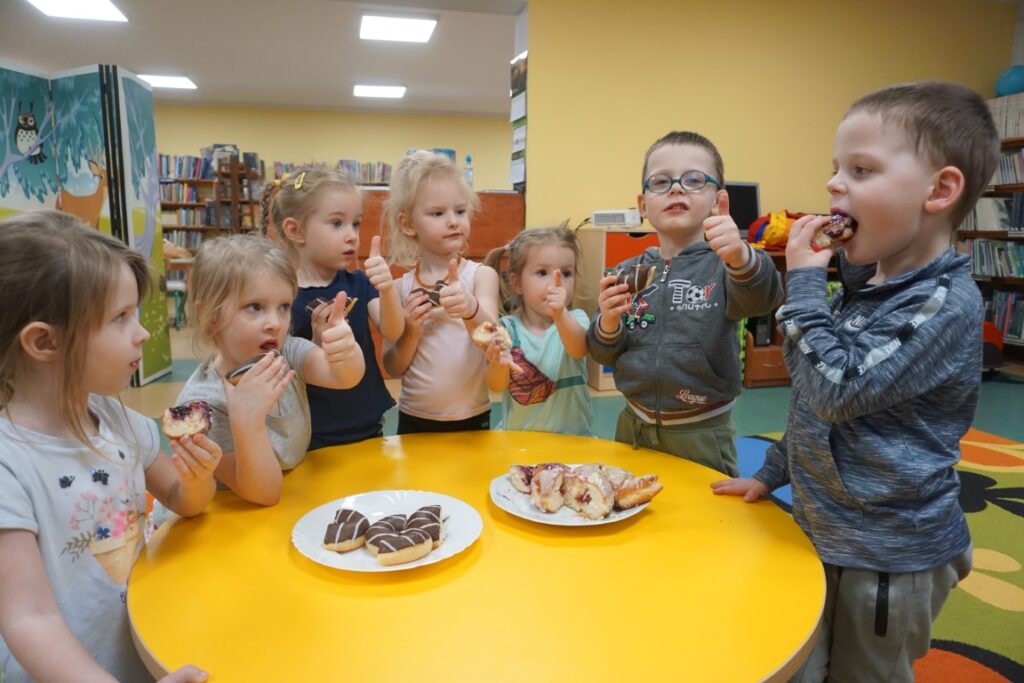 Dzieci przy stoliku z pączkami